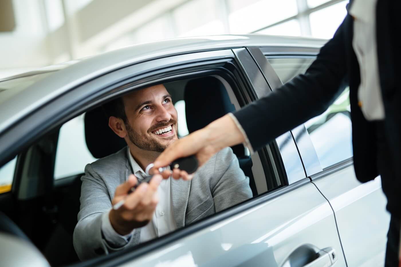A happy customer receiving the keys to his car at Monterey Motor Cars
